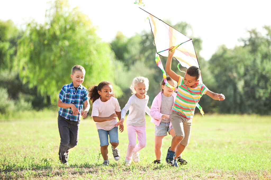 Group of happy children with kite in park